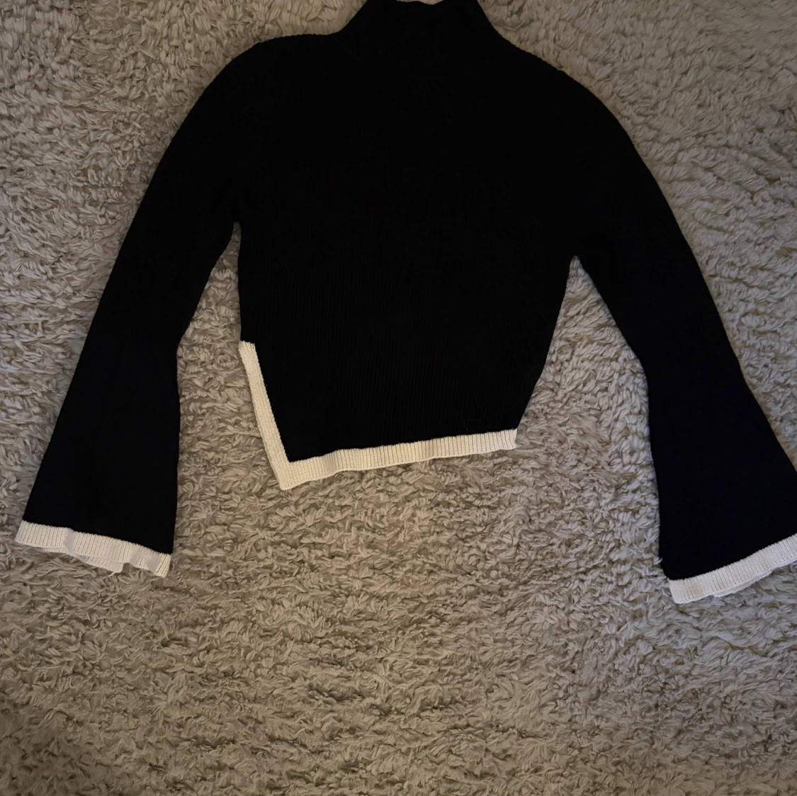 Svart polotröja med vita detaljer