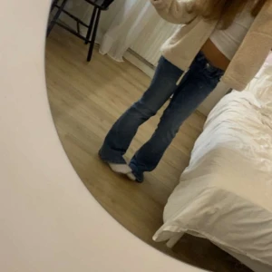 Blå bootcut jeans med låg midja - Säljer ett par snygga blå jeans med bootcut-modell och låg midja. Jeansen har klassisk femficksdesign och är tillverkade i ett mjukt denimtyg som sitter skönt. Perfekta för dig som gillar en retro vibe och vill ha ett par jeans som sticker ut. Lappen finns inte kvar och köpte begagnade här på plick men sitter som xs/s.