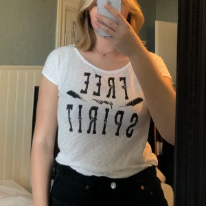 Vit t-shirt med tryck från Rut&Circle - Vit t-shirt från Rut&Circle med svart text ”Free your spirit”. T-shirten har rund halsringning, korta ärmar och är väldigt tunn. 