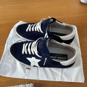Golden Goose Superstar sneakers marinblå - Tjena! Jag säljer dessa extremt fett gg skor. Skicket är 9/10 och har inga defekter, men de har använts ett fåtal gånger endast skorna och dustbag ingår. Frakt inom 24 h alltid!