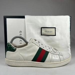 Gucci Ace  - Gucci Ace sneakers i vitt skinn med klassiska gröna och röda ränder på sidorna.Dom är väldigt feta nu till hösten och är i bra skick du får med allt som är på bilden.Skorna är också själv klart äkta.Skorna kommer in i veckan.Skorna är storlek 39 men sitter stort så passar dig som har 40.tveka inte på att skriva till för en bra och smidig affär.priset kan diskuteras  🙌🏼🙌🏼🙌🏼