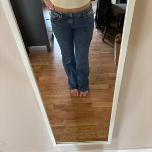 Lågmidjade bootcut jeans - Blåa lågmidjade bootcut jeans, väldigt bra skick, endast dåligt uppsydda. Storlek står ej i men jag ser de som en S