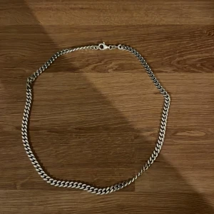 Kedjehalsband i silver - Stilrent halsband, platta länkar i silverfärg. Kedjan har en klassisk karbinhake och passar perfekt för dig som gillar en clean och modern look. Snygg att bära ensam eller att kombinera med andra smycken för en personlig stil. Halsbandet är 48,5cm långt när de är uppknäppt och cirka 0,5cm brett men även riktigt silver 925 är ingraverat som ett bevis. Men skriv privat för lite mer information och pris💸