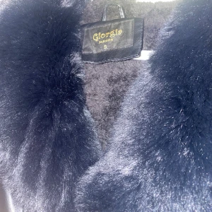 Svart pälsjacka från Giorgia Fashion - Säljer en svart pälsjacka från Giorgia Fashion i storlek S. Jackan har lyxig fuskpäls på krage, ärmslut och insida samt slät skinnlook på utsidan. Snygg och varm modell med knappar framtill och fickor på sidorna. Perfekt statement-plagg för kalla dagar.