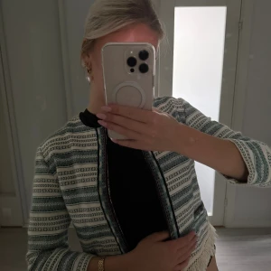 Mönstrad overshirt från Bershka trekvartsärm - Säljer en snygg overshirt från Bershka med grön- och svartmönstrade ränder på vit botten. Jackan har croppad passform, rund hals och fransdetalj nedtill. Perfekt för dig som vill sticka ut lite extra med din stil.