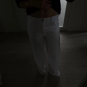 Vita wide jeans från Zara  - Säljer ett par vita jeans med raka, vida ben. Klassisk femficksmodell med knapp och dragkedja framtill. Snygg och clean look som passar perfekt till sneakers eller boots. Materialet är jeans och de har en riktigt fräsch vibe.