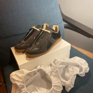 Maison Margiela Gats svart/grå - Tjena! Nu finns dessa två tvärfeta Maison margiela gats till salu i färgen svart och grå. Storlek 44 och allt OG ingår vid köp. OBS dessa skor är INTE äkta men ändå i toppkvalitet som originalet. Lådan har en defekt som syns på bilderna.