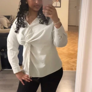 Vit skjorta med knyt från SHEIN - Snygg vit skjorta från SHEIN med lång ärm och unik knytdetalj framtill. Skjortan har klassisk krage och är tillverkad i ett lätt, strukturerat material som ger en modern look. Perfekt för dig som gillar stilrena plagg med en twist. Älskar😍