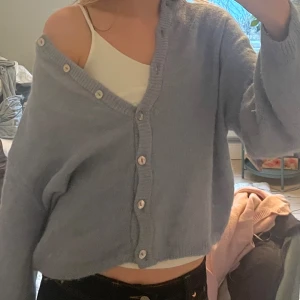 Ljusblå stickad kofta med knappar - Supermysig ljusblå stickad kofta som man kan bära off shoulder men också helknäppt! Koftan är använd max 2-3 gånger alltså som ny! Tröjan har inga skador eller lösa trådar! Skriv till mig privat innan ni trycker på köp så jag är beredd att posta osv!💕