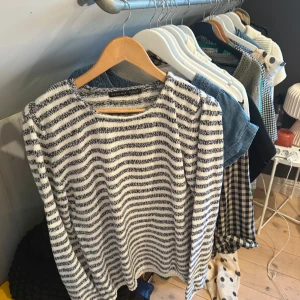 Randig stickad tröja från Zara Man - Säljer en stickad tröja från Zara Man i storlek L. Tröjan är vit med svarta horisontella ränder och har en klassisk rund halsringning samt långa ärmar. Perfekt för dig som gillar en avslappnad men ändå stilren look.