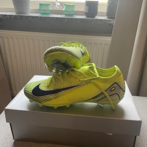 Nike fotbollsskor gul/svart Gripknit - Säljer ett par Nike Mercurial Vapor 16 Elite AG. Skorna är i mycket bra skick, endast färgats lite på grund av spel på konstgräs. Tillverkade i syntetmaterial med Gripknit-överdel för extra grepp. Kommer med tillhörande påse och kartong.