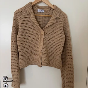Beige cardigan från Lindex  - Säljer en beige stickad kofta från Lindex. Koftan är virkad med genomgående hålmönster, har krage, långa ärmar och knäppning framtill med fyra knappar. Perfekt inför hösten🤩