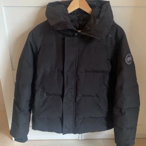 Svart dunjacka från Canada Goose XS - Säljer en svart dunjacka från Canada Goose i storlek XS men passar mig som är S 175cm. Jackan har en rejäl huva, diskret logga på ärmen och dragkedja framtill. Perfekt för kalla dagar och riktigt snygg streetstil. Klassisk pufferlook och riktigt varm.