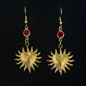 Guldiga örhängen med hjärtan och röd sten - Handgjorda och unika guldörhängen 🤩 Öronhängerna är nickelfria och guldpläterade i kirurgiskt stål, resterande av örhänget är i rostfritt stål (ej guldpläterat) 💕🙏 5 cm långa. Alla köp görs via ”KÖP NU” knappen.  💐
