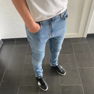 Tiger of Sweden Jeans - Säljer ett par ljusblå skinny jeans från tiger of Sweden i modellen Pistolero. Jag är 185 och väger 77kg. Jeansen har klassisk femficksdesign, normal midja och smal passform hela vägen ner. Tillverkade i mjukt denimtyg med snygga slitningar och detaljerade sömmar.