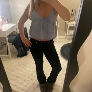 Ljusblå linnetopp från Primark - Supersöt ljusblå linnetopp från Primark med broderade håldetaljer och v-ringning. Toppen är croppad och har tunna axelband, perfekt för varma dagar. Tillverkad i bomull och har en luftig, flowy passform som känns chill och somrig.