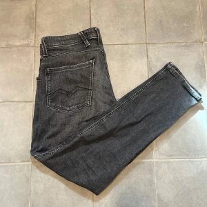 Replay jeans - Säljer ett par mörkgrå svarta Replay jeans med klassisk femficksdesign. Snygg mörkgrå färg. Storleken är W31 L30 hör av er vid funderingar