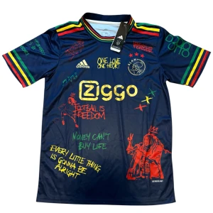 Ajax x Bob Marley Adidas fotbollströja - Ajax x Bob Marley limited edition fotbollströja i mörkblått med färgglada detaljer i rött, gult och grönt. Tryck med citat, illustrationer och Ajax-logga i guld. Kortärmad modell i lätt funktionsmaterial, perfekt för dig som vill sticka ut på planen.