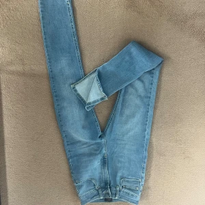 Blå skinny jeans med klassisk look - Snygga blå skinny jeans med hög midja från nelly. Väldigt stretchiga. Knappt använda.