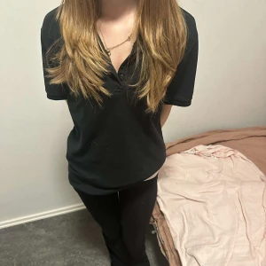 Svart t-shirt med v-ringning - En polo ralph lauren tröja som är mörk blå med en rosa loga 