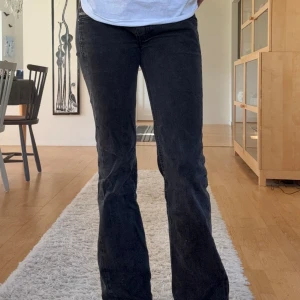 Svarta bootcut jeans från Diesel - Snygga svarta Diesel Doozy jeans med bootcut passform och låg midja. Jeansen är i stretchigt denim som sitter skönt och har klassiska fem fickor samt diskreta detaljer. Perfekta för dig som gillar en avslappnad men ändå stilren look.