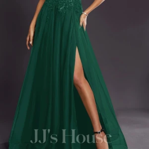 Grön bakklänning med spetsdetaljer - Mörkgrön långklänning från JJ's House med smala axelband, djup v-ringning och spetsdetaljer upptill. Kjolen är luftig med hög slits och faller snyggt. Perfekt för bal