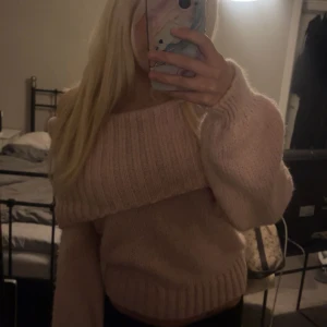 Ljusrosa offshoulder stickad tröja Gina Tricot - Superfin ljusrosa stickad tröja från Gina Tricot i offshoulder-modell. Tröjan har bred ribbad kant upptill, ballongärmar och är riktigt mjuk och mysig. Perfekt för dig som vill ha en söt och trendig look med lite extra volym i ärmarna.