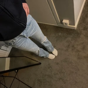 Blå jeans från Gina  - Säljer dessa fina jeans med hål då dem knte kommer till användning längre. Storlek 158 som xxs elr xs eftersom dem är baggy bootcut💕