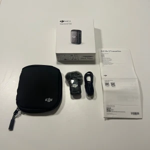 DJI Mic 2 Transmitter - DJI Mic 2 Transmitter i mycket fint skick, komplett med originalförpackning, skyddsväska, vindskydd, USB-kabel och manual. Perfekt för trådlös ljudinspelning med hög kvalitet. Inga synliga defekter eller slitage, ser ut som ny. Aldrig använd!