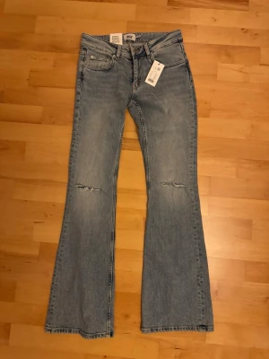 Bootcut jeans  - Helt nya jeans, low boot full length med slitna detaljer vid knäna. Strl S. 