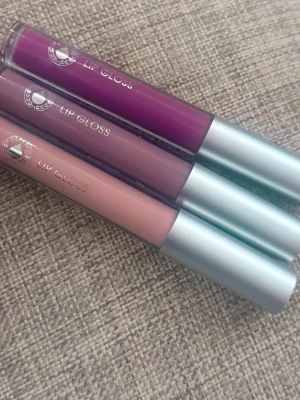 3-pack läppglans i olika färger används bara en gång  - Säljer ett set med tre läppglans från Depend. Färgerna är lila, mauve och nude. Alla kommer i smidiga tuber med silverfärgade lock och transparent hylsa så du ser färgen tydligt. Perfekt för dig som vill variera din look med både färgstarkt och neutralt.