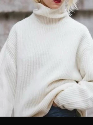 Vit ribbad polotröja stickad - Mysig oversized polotröja i ribbstickad modell. Tröjan är vit, har långa ärmar och hög polokrage som ger en riktigt chill vibe. Perfekt att bära till jeans eller leggings när det är kallt ute. Materialet känns mjukt och värmande, i ull!