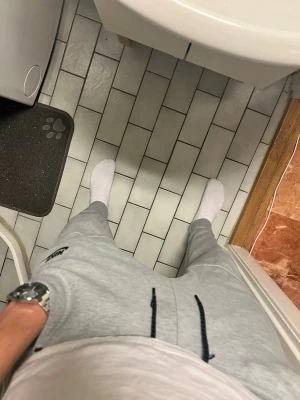 Nike tech  - Säljer ett par grå mjukisbyxor från Nike i storlek S. Byxorna har svarta snören i midjan och dragkedja på fickan. Tillverkade i mjukt bomullsmaterial och har en relaxed passform som är perfekt för chill dagar eller träning.