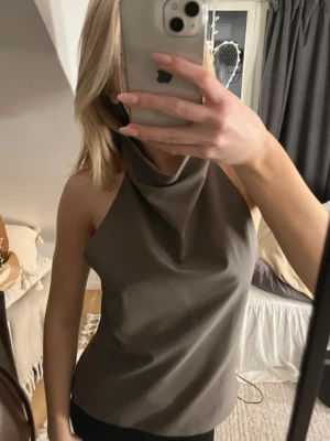 Grä halterneck topp - En grå jättefin halterneck topp från Zara med hög, draperad krage och öppen rygg. Sitter super snyggt mot kroppen och är helt ny! 🩶
