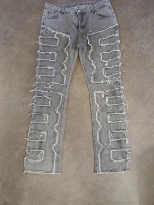 Grå jeans med råa detaljer, storlek XL. Från Temu.  - Grå jeansbyxor från Temu i storlek XL med grova, råa och fransade detaljer längs benen. Materialet är 90% bomull och 10% spandex vilket ger både komfort och stretch. Modellen har klassisk femficksdesign och raka ben med edgy look.