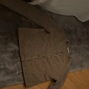 BRUN STICKAD KOFTA🧸 - Mysig brun kofta från Gina Tricot i premiumkvalitet. Koftan har rund halsringning, långa ärmar och knäppning med bruna knappar framtill. Perfekt att slänga på sig när det är kyligt ute.   Själv är jag 158 och passar mig perfekt och för folk som vill ha den lite kort i magen i aramarma är det inga problem!❤️