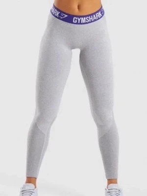 Grå Gymshark leggings  - Gråa leggings från Gymshark med bred blå resår i midjan där loggan syns. Tight passform och stretchigt material. Med detaljer på bakdelen.