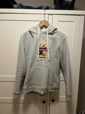 Polo Ralph lauren hoddie - Polo Ralph lauren med klassisk björn på. Storleken är m men passar med xs/s. Skick 8/10 och väldigt bra kvalitet. Passar nog 65kg 180cm ish. Skicka bud vad som. Kan släppa billigt vid smidig affär
