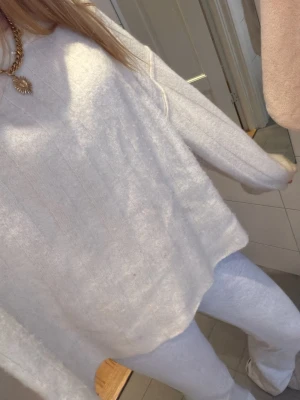 Vit stickad oversized tröja - Mysig vit stickad tröja med oversized passform och diskret ribbat mönster. Tröjan har rund halsringning och långa ärmar, perfekt för lager-på-lager under kyliga dagar. Superenkel att styla till både jeans och mjukisbyxor.(ginatricot premium quality)