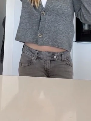 Grå bootcut jeans  - Säljer ett par gråa bootcut jeans från laget  157  med snygg broderad detalj på bakfickorna. Jeansen har låg midja, klassisk femficksdesign och stängs med dragkedja och dubbla knappar. Jeansen sitter väldigt bra i midjan💕 nästan aldrig använts 