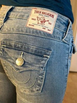true religion jeans - Superfina jeans i storlek 24. Endast använda fåtal gånger. Uppsydda och avklippta hemma för att anpassa min längd (160cm) , se bild. Inget man tänker på eller som syns när dom sitter på. Bud mottages 