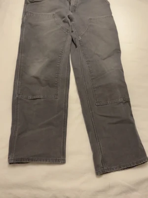 Grå doubleknee pants från Carhartt - Dem är thriftade för något år sen är i bra skick strl 34/32