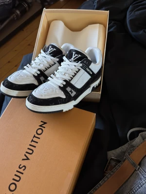 Louis Vuitton skor - Säljer ett par Louis Vuitton sneakers i svart och vitt, Storlek 44 passar 43 också. Dom är använda ett få antal gånger och inget slitage på dom förutom såklart på sulan, annars extremt fint skick! Dust bag och LV lådan följer med. Hör av er vid frågor, priset är diskuterbart vid snabb affär!
