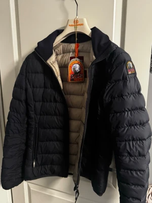 Mörkblå dunjacka från Parajumpers L - Parajumpers jacka Geena, i färgen navy. Storlek L. Den är köpt på Miinto.se för ett tag sen. Säljs i befintligt skick men är sparsamt använd och nästan som helt ny. Man kan scanna qr koden så får man upp att den är äkta. Jätte fin jacka som passar alla årstider. Nypris är mellan 3800-4500kr. 