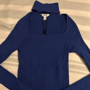  Ny Blå ribbad polotopp från AWARE - Säljer en snygg blå polotopp från AWARE i storlek S. Toppen är ribbad med lång ärm och har en hög krage som ger en cool vibe. Materialet är mjukt och stretchigt, perfekt för att styla med jeans eller kjol. Fyrkantig halsringning för en modern look.