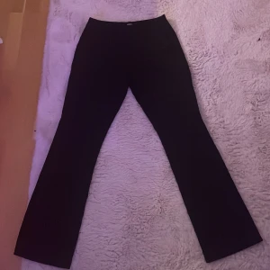Svarta bootcut kostymbyxor - Svarta perfekta kostymbyxor från Bik Bok storlek 36, med låg midja och utsvängda längt nere. 💗de sitter inte så pösigt som det ser ut på bilden💗Använda men är ändå i bra skick, inga tecken på skador. Fickor fram men inte bak. Kontakta vid intresse, frågar eller annat. Pris kan diskuteras och vid köp välj helst Instabox eller Postbord, blir lättast att frakta!