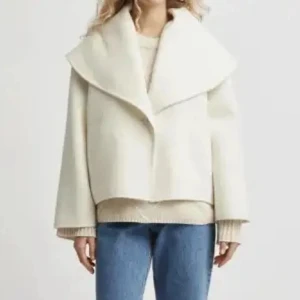 Vit kappa från Stylein - Säljer en stilren vit kappa med bred, svepande krage och rak passform. Jackan har en minimalistisk look och är perfekt för dig som gillar clean och modern stil. Materialet är ylle.