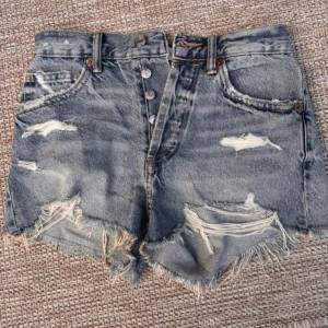 Blå slitna jeansshorts från Zara - Snygga blå jeansshorts från Zara, slitna detaljer och fransig kant.💗💗