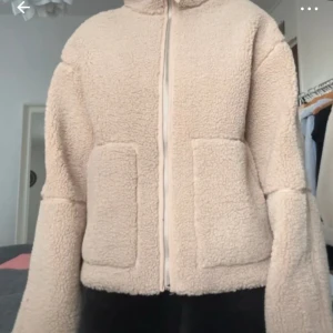 Beige teddyjacka  - Mysig beige teddyjacka med två stora fickor framtill och hel dragkedja. Jackan har en hög krage och är långärmad med en loose passform. Storleken är 158/164 men passar på mig som är S och 176cm lång. 