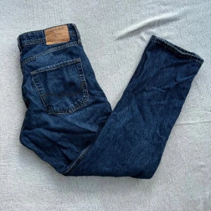 Blå jeans från Jack & Jones - Snygga blå jeans från Jack & Jones med klassisk femficksdesign och bruna sömmar